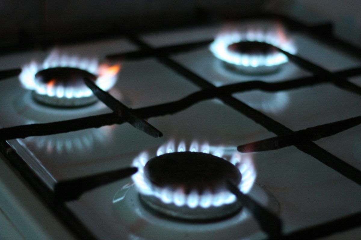 Gas cooktop burners lit with blue flames